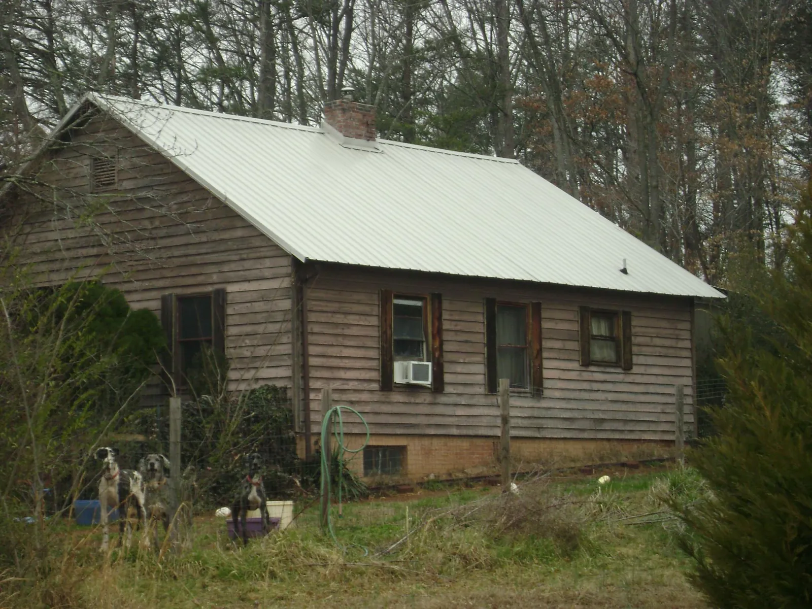 White metal roof on an old wood sided farmhouse, from a Metal Roof Installation job in Wellsville